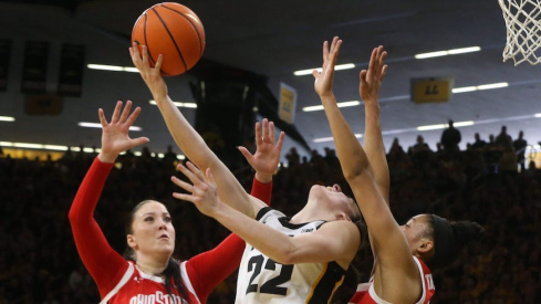 Caitlin Clark attempting a reverse layup vs. Rebeka Mikulasikova and Taylor Thierry