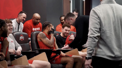 Jake Diebler signing his contract in front of the team