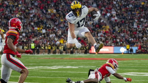 Michigan tight end Marlin Klein hurdles a Maryland defender