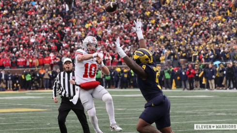 Julian Sayin throwing a pass over a Michigan defender