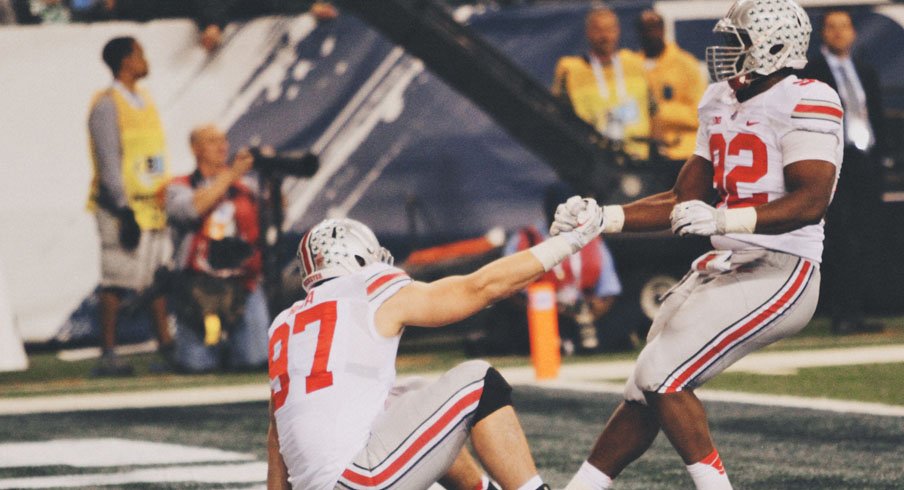 Adolphus Washington of Ohio, helps Florida native Joey Bosa to his feet.