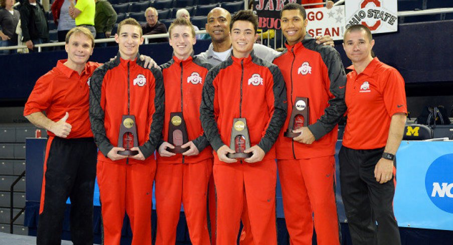 Men's gymnastics team with trophies