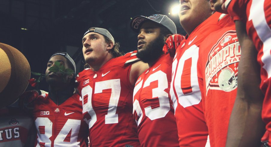 Joey Bosa and Michael Bennett sing Carmen Ohio with teammates following the Big Ten Championship game.
