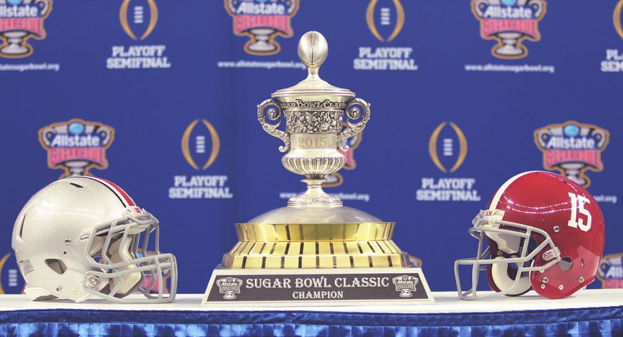 Ohio State and Alabama helmets next to the 2015 Sugar Bowl trophy.