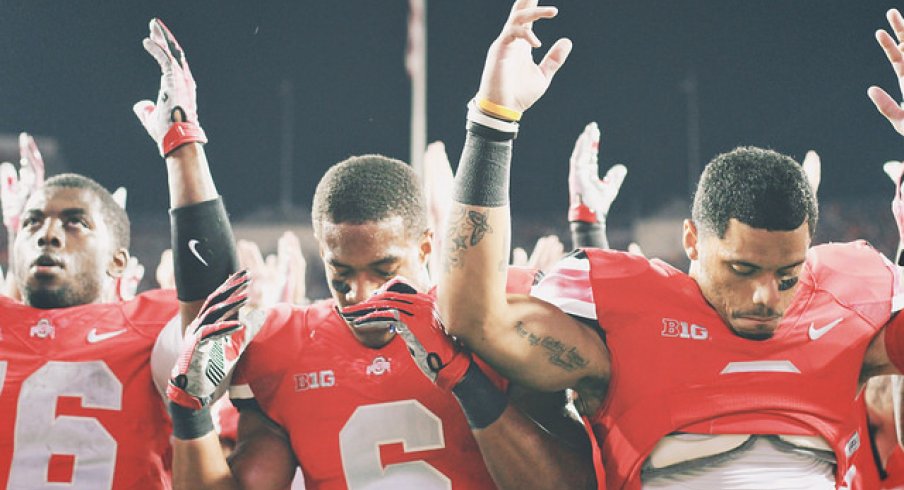J.T. Barrett, Evan Spencer, and Devin Smith sing Carmen Ohio with deflated spirits. 
