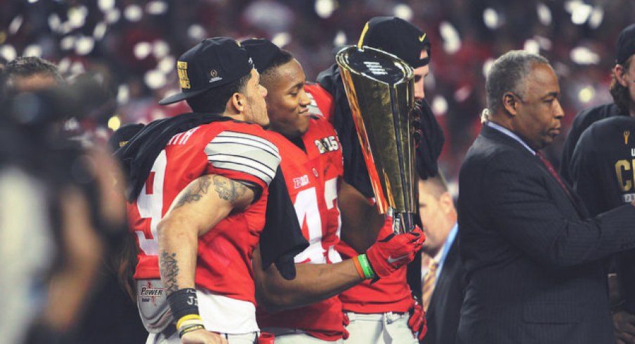 Devin Smith (left) and Darron Lee (right) spend time with the CFP trophy.