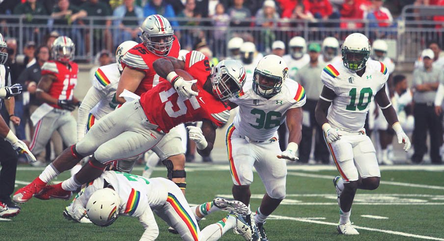 Ezekiel Elliott is upended by a Hawai'i defender.