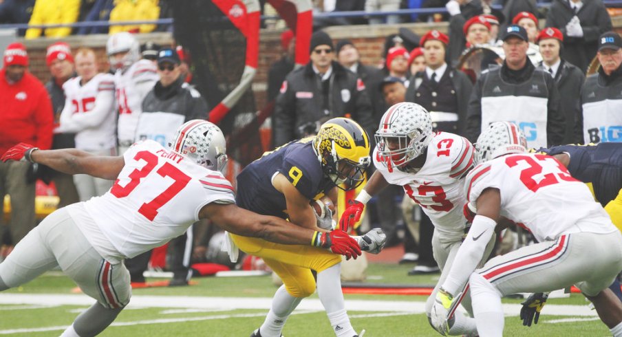 Joshua Perry, Eli Apple and Tyvis Powell combine to make a tackle vs. Michigan.