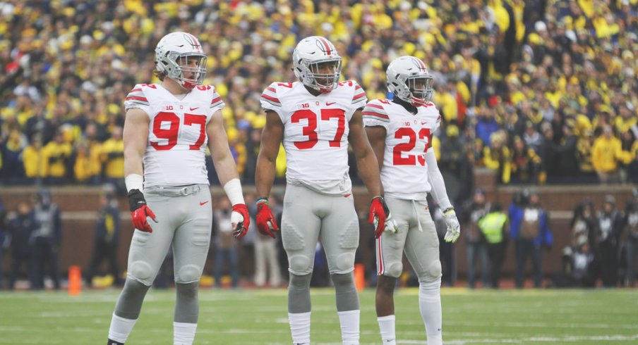 Joey Bosa, Joshua Perry and Tyvis Powell on the field against Michigan.