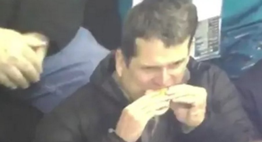 Jim Harbaugh eating a hot dog like a creep.