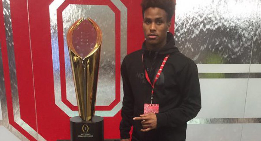 Kareem Felder poses next to Ohio State's national championship trophy