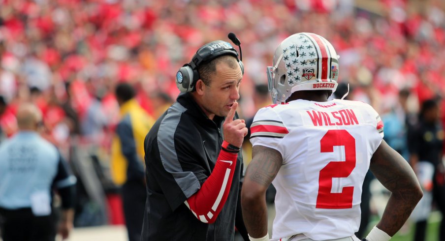 Zach Smith speaks with Dontre Wilson on the sideline.