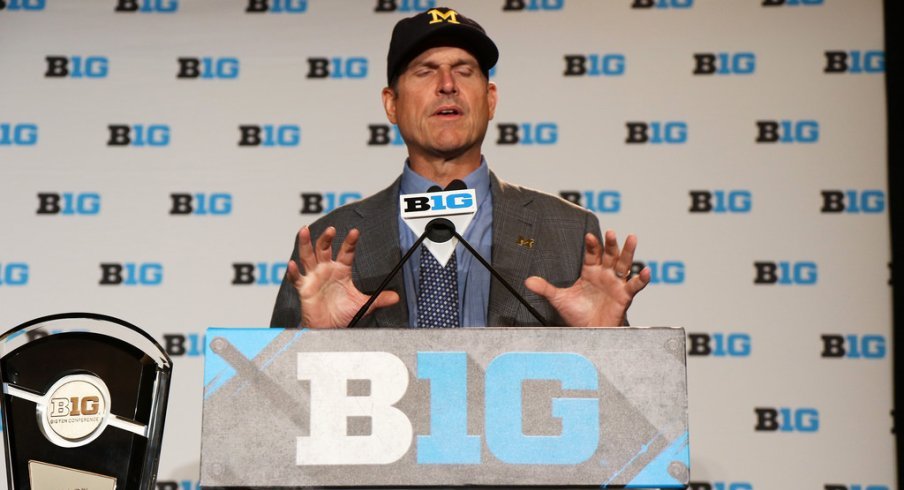 Fortune teller Jim Harbaugh performs at the B1G Football Media Carnival.