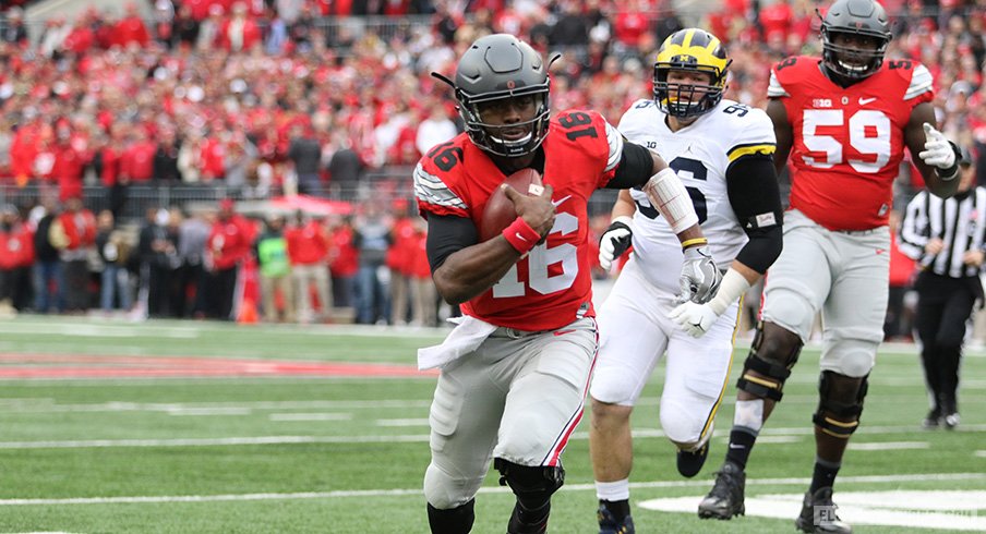 J.T. Barrett carries the ball against Michigan. 