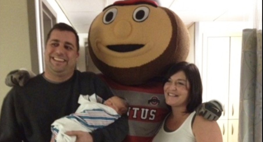 Corey, his son Zade, and wife, Amber, pose with Brutus Buckeye