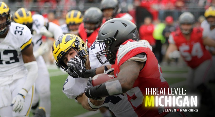 Ohio State running back Mike Weber stiffarms a Michigan Wolverine