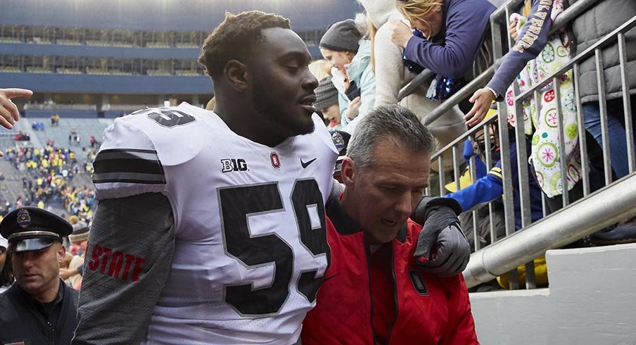 Tyquan Lewis and Urban Meyer exit the field following Ohio State's 31-20 win over Michigan