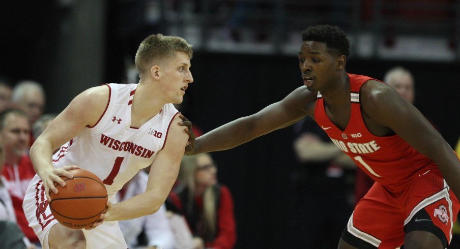 Ohio State basketball player Jae'Sean Tate guards a Wisconsin player