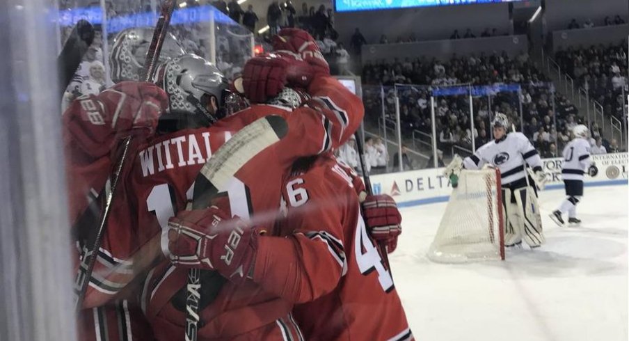 Sad Penn State goalie looks on as the Buckeyes celebrate one of their five goals.