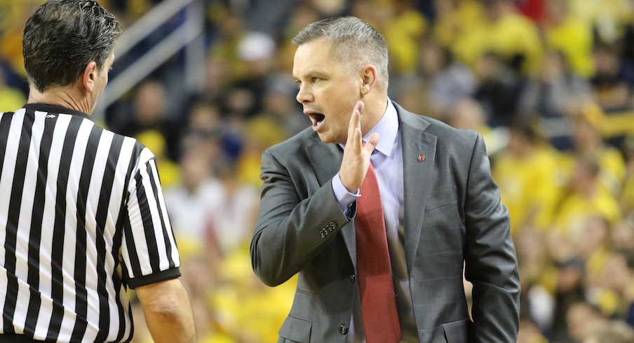 Chris Holtmann talking to official Gene Steratore during Sunday's game at Michigan.