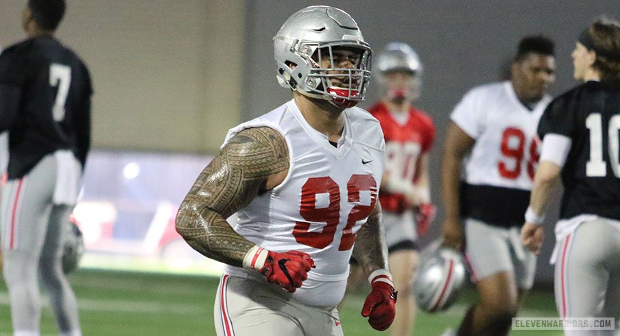 Haskell Garrett (92) running with quarterbacks Dwayne Haskins (7) and Joe Burrow (10) in the background.