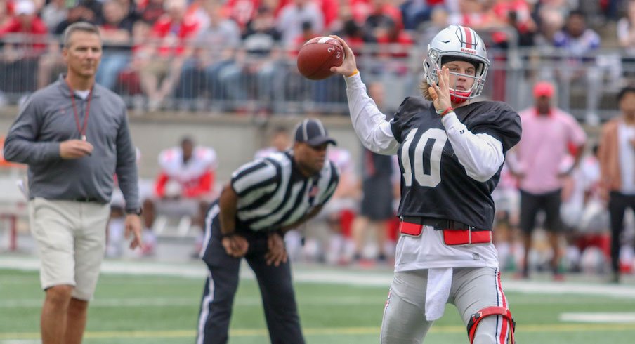 Urban Meyer looks on as Joe Burrow throws a pass.