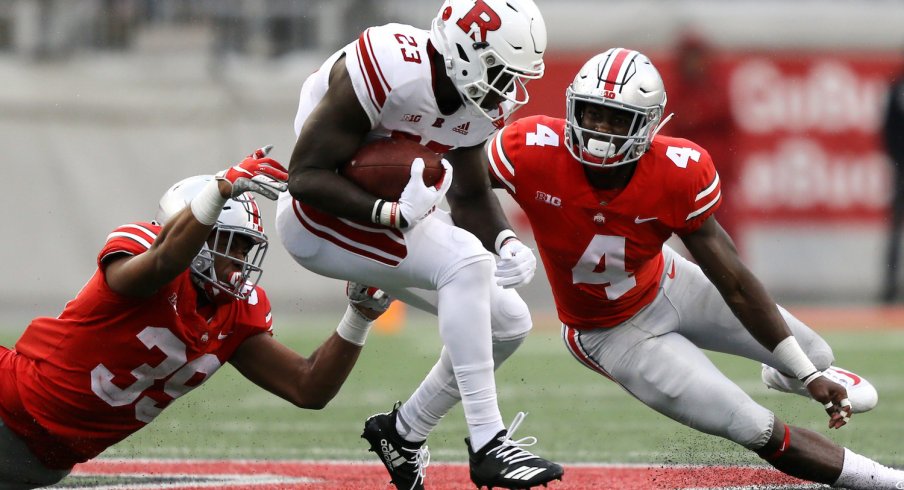 Jordan Fuller and Malik Harrison combine for a tackle against a Rutgers ballcarrier. 