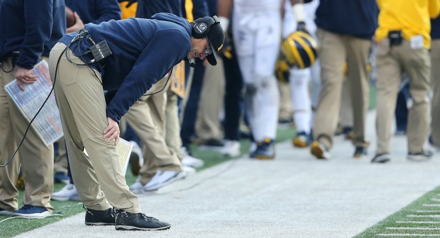 Jim Harbaugh inspects the ground in Ohio Stadium. 