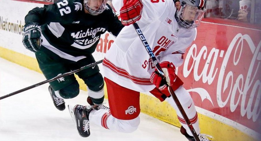 Buckeye forward Freddy Gerard races Spartan defenseman Dennis Cesana to the puck.