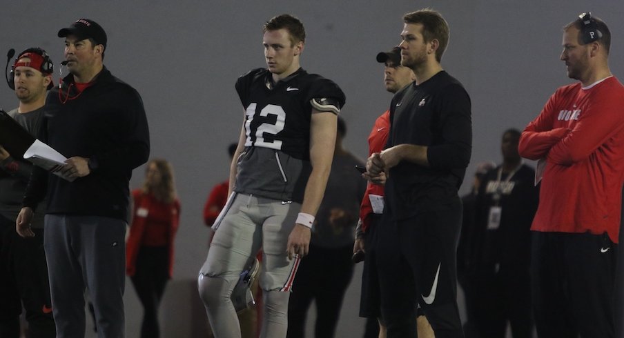 Matthew Baldwin watches a play alongside members of Ohio State's coaching staff during spring practice.
