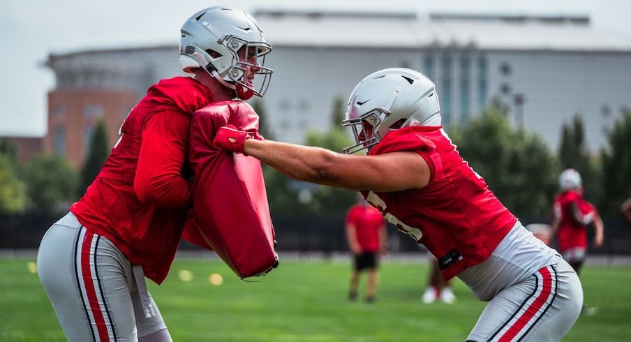 Tight ends run through a blocking drill in practice.