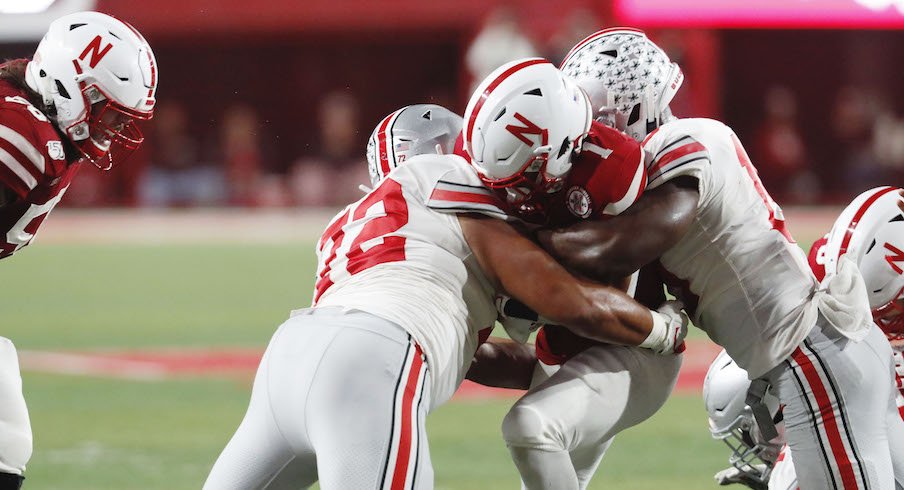 Tommy Togiai (72) and Dallas Gant tackle Nebraska's Wan'Dale Robinson