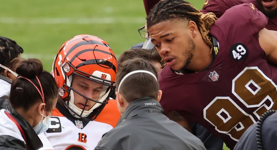 Nov 22, 2020; Landover, Maryland, USA; Cincinnati Bengals quarterback Joe Burrow (9) shakes hands with Washington Football Team defensive end Chase Young (99) prior to being carted off the field after injuring his left knee in the third quarter at FedExField. Mandatory Credit: Geoff Burke-USA TODAY Sports