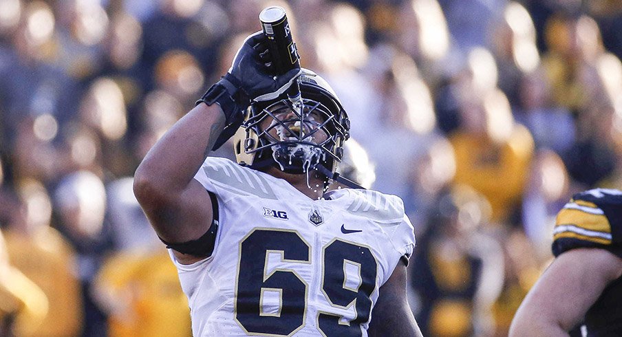 Purdue offensive lineman Greg Long pours a can of Bud Light over his face after an Iowa fan tossed the beer onto the field