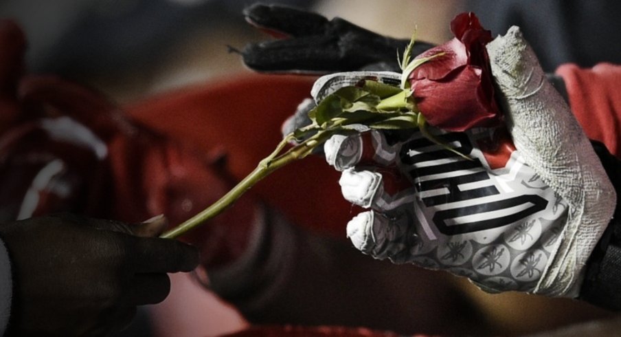 Jan 1, 2019; Pasadena, CA, USA; Ohio State Buckeyes quarterback Dwayne Haskins Jr. (left) hands out roses after defeating the Washington Huskies in the 2019 Rose Bowl at Rose Bowl Stadium. Mandatory Credit: Kelvin Kuo-USA TODAY Sports