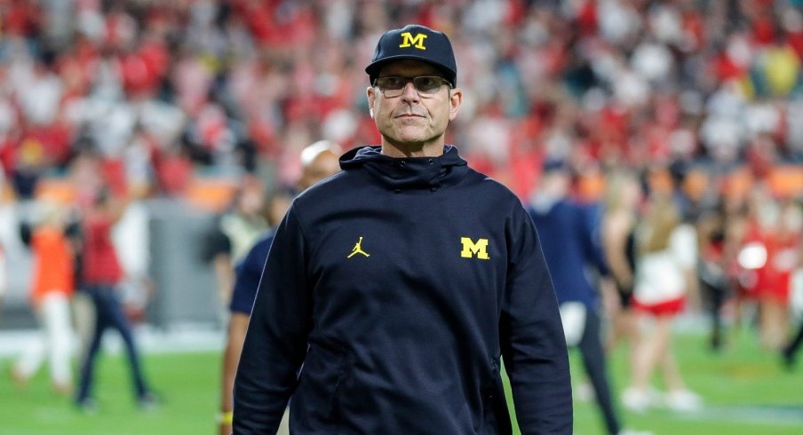 Jim Harbaugh walks off after a College Football Playoff loss