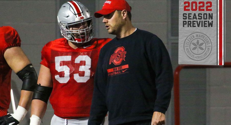 Ohio State offensive line coach Justin Frye speaks with center Luke Wypler during practice