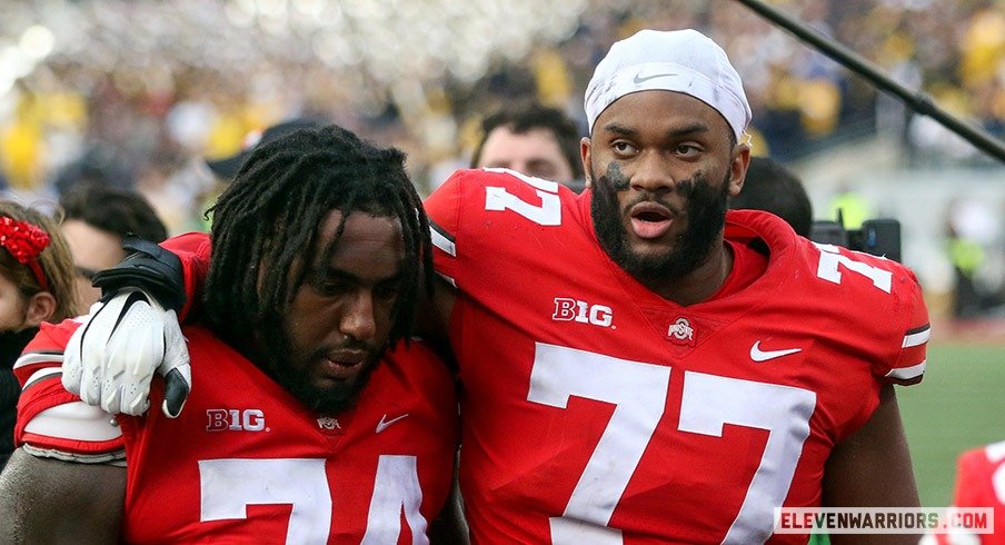 Donovan Jackson and Paris Johnson leave the field after losing to Michigan