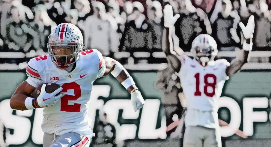 Oct 8, 2022; East Lansing, Michigan, USA; Ohio State Buckeyes wide receiver Emeka Egbuka (2) heads up field and scores after a catch in the first quarter of the NCAA Division I football game between the Ohio State Buckeyes and Michigan State Spartans at Spartan Stadium.