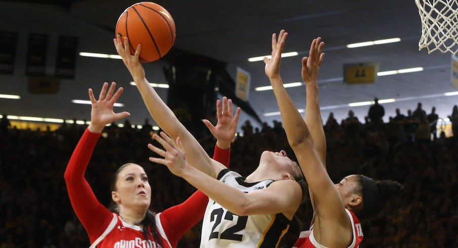 Caitlin Clark attempting a reverse layup vs. Rebeka Mikulasikova and Taylor Thierry