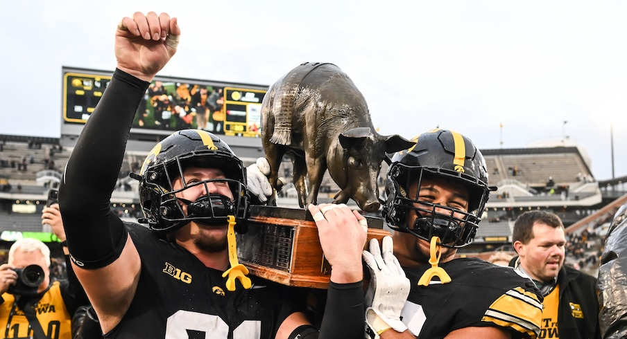 Iowa’s Jonah Pace and Bryce Hawthorne celebrate with the Floyd of Rosedale
