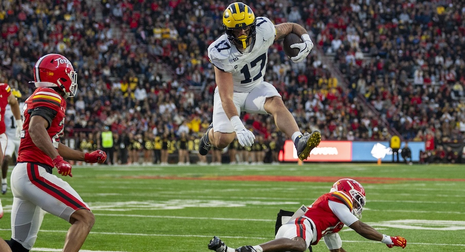 Michigan tight end Marlin Klein hurdles a Maryland defender